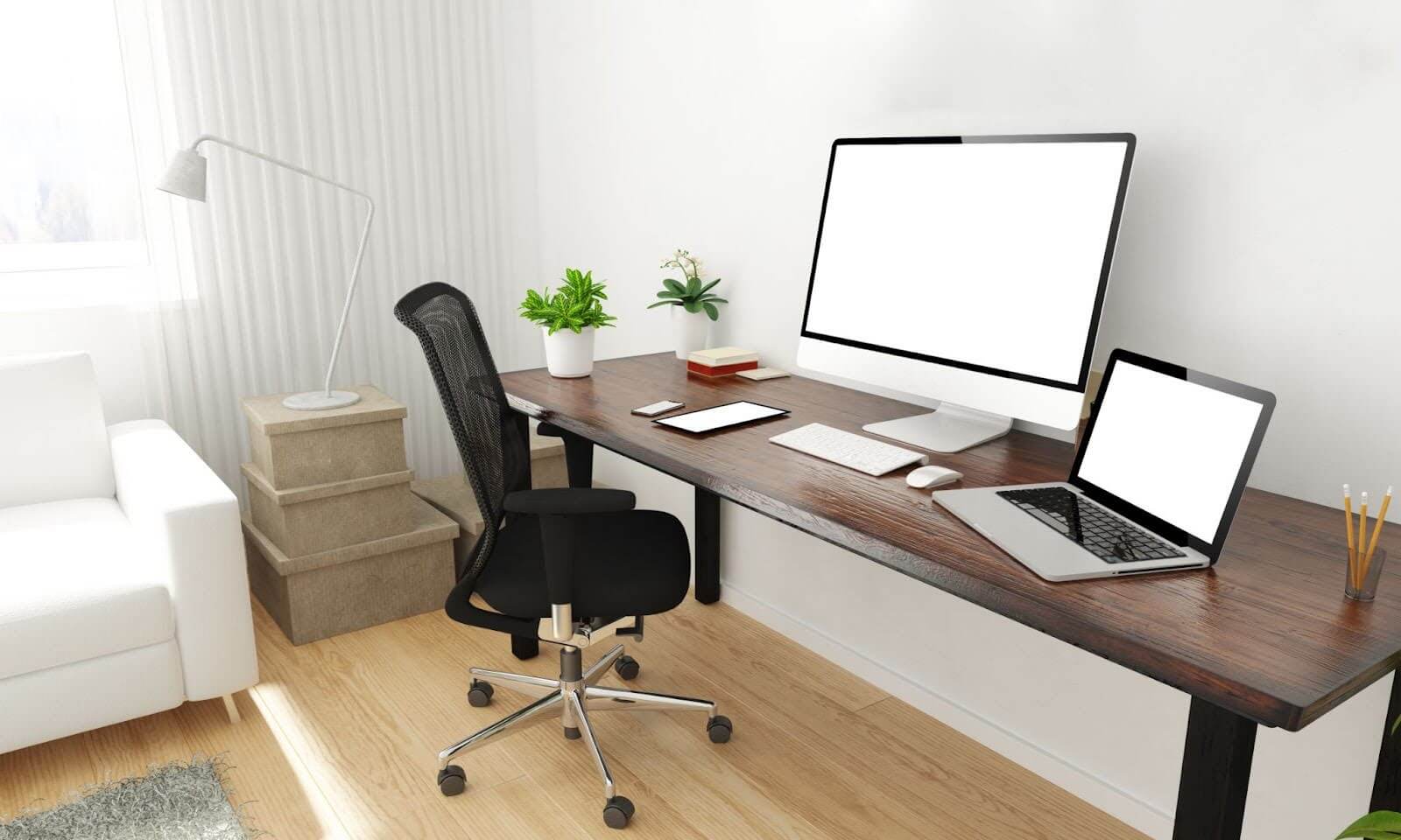Minimal home office setup with a long wooden desk, large monitor, laptop, mesh chair, desk lamp, indoor plants, and natural light from a window
